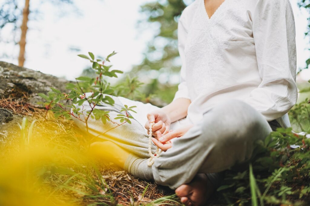 Young smiling woman practice yoga outdoors in forest. Physical and mental health